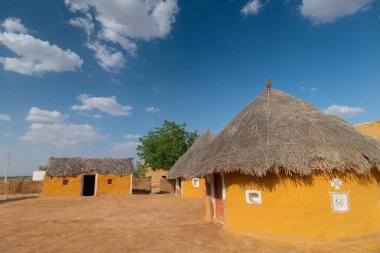 Jaisalmer, Rajasthan, India - 15th October 2019 : Colorful huts in Rajsathani village, Jaisalmer, India. Blue sky and white clouds background.