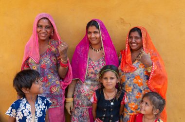 Jaisalmer, Rajasthan, India - 15th October 2019 : Smiling and happy Rajasthani women and children in local costume, posing in a Rajasthani village.
