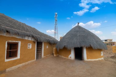 Jaisalmer, Rajasthan, India - 15th October 2019 : Colorful huts in Rajsathani village, Jaisalmer, India. Blue sky and white clouds background.