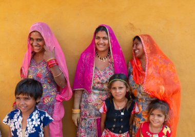 Jaisalmer, Rajasthan, India - 15th October 2019 : Smiling and happy Rajasthani women and children in local costume, posing in a Rajasthani village.