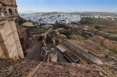Top view of Mehrangarh fort with distant view of blue city Jodhpur, Rajasthan, India. Blue sky with white clouds in the background. Historical Fort is UNESCO world heritage site