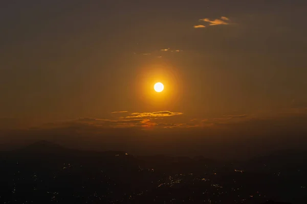 Rise of the orange moon, also known as the harvest moon or the hunter\'s moon, over the night sky at Sikkim, India. Moon orange due to atmosphere.