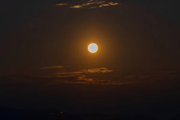 Rise of the orange moon, also known as the harvest moon or the hunter\'s moon, over the night sky at Sikkim, India. Moon orange due to atmosphere.