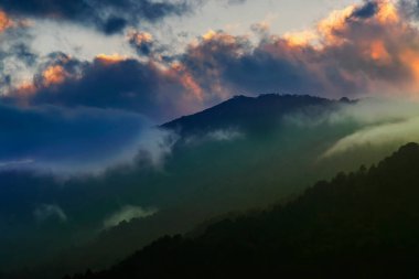 Colourful clouds above Himalayan mountain range after sun has set beyond the mountain peaks. After sun set nature stock image , shot at Okhrey, Sikkim, India.