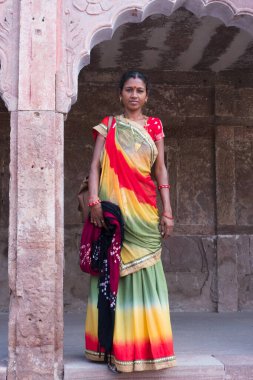 Jodhpur, Rajasthan, Hindistan - 19 Ekim 2019: Mehrangarh kalesinde geleneksel renkli rajasthani elbiseler giyen güzel orta yaşlı Rajasthani kadın. Rajasthan renklerle dolu..
