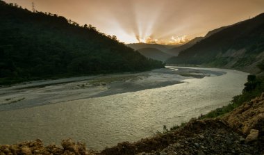 Tista nehri üzerinde güzel bir günbatımı, Himalaya dağları, Sikkim, Hindistan. Teesta Nehri, Himalayalar 'ın Pauhunri Dağı' ndan yükselen ve Sikkim ve Batı Bengal boyunca akan uzun bir nehirdir..