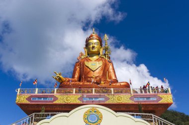 Guru Padmasambhava 'nın kutsal heykeli ya da bir nilüferden doğan Guru Rinpoche, Tibet' te Vajrayana 'ya ders veren Hintli tantrik Budist Vajra üstadıdır. Mavi gökyüzü ve beyaz bulutlar, Samdruptse, Sikkim, Hindistan.
