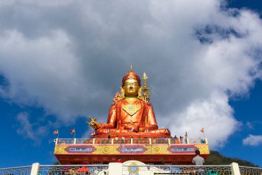 Guru Padmasambhava 'nın kutsal heykeli ya da bir nilüferden doğan Guru Rinpoche, Tibet' te Vajrayana 'ya ders veren Hintli tantrik Budist Vajra üstadıdır. Mavi gökyüzü ve beyaz bulutlar, Samdruptse, Sikkim, Hindistan.