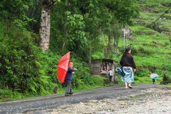 Sikkim, Hindistan - 5. Benim 2008 'im: okula giderken okul çantasını taşıyan annesini takip eden kırmızı şemsiyeli sevimli küçük Sikkimese öğrenci. Sikkim yüksek okur yazarlık oranıyla ünlüdür..