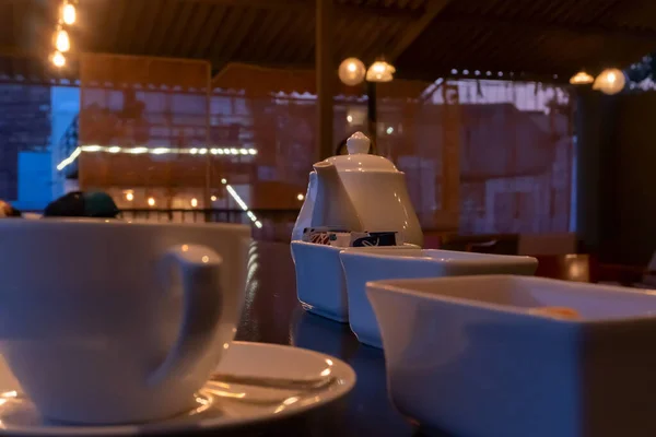 インドのラジャスタン州ジョードプルにあるレストランの美しいインテリアビュー 輝くテーブルの上に装飾されたライトの反射を持つ白いカップ 料理やティーポット — ストック写真