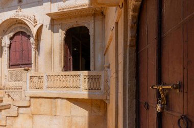 Jaisalmer kalesi, Rajasthan, Hindistan - 15.10.2019: Kum taşı güzel bir balkon, jharokha, taş pencere ve Rani Mahal 'in dışı veya Rani Ka Mahal, iç kale yaptı. UNESCO Dünya Mirası.