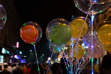 Kolkata, Batı Bengal, Hindistan - 26.12.2018: Aydınlanmış Park caddesinde renkli balonlar, ışıklar ve Noel kutlaması neşe dolu son buluyor. Karanlık gökyüzü arkaplanı.