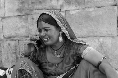 Jaisalmer, Rajasthan, Hindistan - 13 Ekim 2019: Rajasthani kadını cep telefonuyla konuşurken gülümsüyor Jaisalmer Kalesi 'nin içinde. Jaisalmer 'in mutlu kadını.