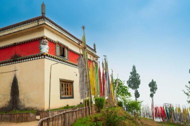Buddist dini dua bayrakları ve ağaçlar Sikkim, Hindistan 'daki manastırın önünde dikiliyor. Mavi gökyüzü arkaplanı.