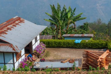 Sikkim, Hindistan - 22 Mart 2004: Sikkim köyünde bir evin önü, ayak tırnaklarını cilalayan genç Sikkimese kadını. Sikkim 'deki kadınlar her zaman iyi giyimli ve terbiyelidir..