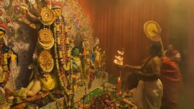 Howrah, India- October 15th, 2021 : Hindu purohit worshipping Goddess Durga with holy lamps on Sandhi Puja, the sacred juncture of Ashtami, eighth day and Nabami, nineth day, as Hindu ritual.