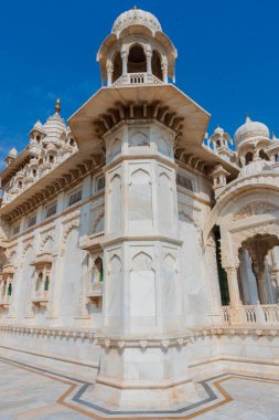 Jaswant Thada Cenotaph, Jodhpur, Rajasthan, Hindistan 'ın güzel manzarası. Karmaşık bir şekilde oyulmuş Makrana mermerinden yapılmıştır. Güneş tarafından aydınlatıldıklarında sıcak bir parıltı yayarlar. Mavi gökyüzü arkaplanı.