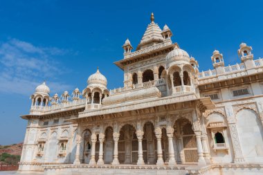 Jaswant Thada Cenotaph, Jodhpur, Rajasthan, Hindistan 'ın güzel manzarası. Karmaşık bir şekilde oyulmuş Makrana mermerinden yapılmıştır. Güneş tarafından aydınlatıldıklarında sıcak bir parıltı yayarlar. Mavi gökyüzü arkaplanı.