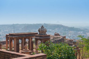 Jaswant Thada Cenotaph 'ın güzel süslü bahçesi. Bahçede balkonlar, katmanlı bir bahçe ve güzel manzaralı küçük bir göl var. Arka planda Jodhpur şehri, Thar çölü ve mavi gökyüzü.