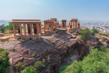 Jaswant Thada Cenotaph 'ın güzel süslü bahçesi. Bahçede balkonlar, katmanlı bir bahçe ve güzel manzaralı küçük bir göl var. Arka planda Jodhpur şehri, Thar çölü ve mavi gökyüzü.