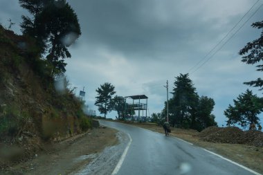 Pauri, Garhwal, Uttrakhand, Hindistan - 3 Kasım 2018: Pauri tepelerinde muson yağmurları. Himalayalar dağlarındaki işlek bir kasabanın yağmurlu sokak görüntüsü. Himalayalar üzerinde iklim değişikliği etkisi.