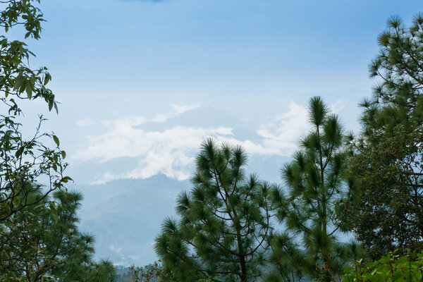 White clouds over distant Himalayan mountains, monsoon landscape of Himalays,Garhwal, Uttarakhand, India. Climate change effect on Himalays bringing landslide,untimely rain,destruction of environment.