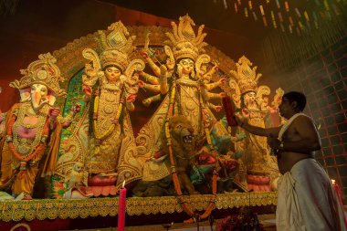 Howrah, Batı Bengal, Hindistan - 3 Ekim 2022: Hindu rahipler Tanrıça Durga 'ya Gaamchaa ile tapıyorlar, geleneksel ince, kalın pamuklu havluyla. Ashtami puja aarati - kutsal Durga Puja ritüeli.