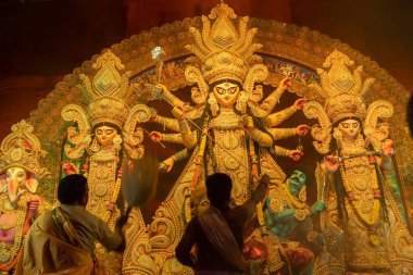 Howrah, Batı Bengal, Hindistan - 3 Ekim 2022: Hindu rahipler kabuk kabuğuyla tanrıça Durga 'ya tapıyorlar. Ashtami puja aarati - kutsal Durga Puja ritüeli - Hinduizm festivali geceleri gerçekleştiriliyor.