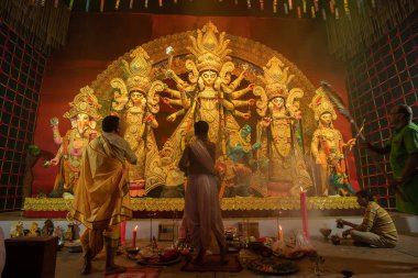Howrah, Batı Bengal, Hindistan - 3 Ekim 2022: Hindu rahipler kabuk kabuğuyla tanrıça Durga 'ya tapıyorlar. Ashtami puja aarati - kutsal Durga Puja ritüeli - Hinduizm festivali geceleri gerçekleştiriliyor.