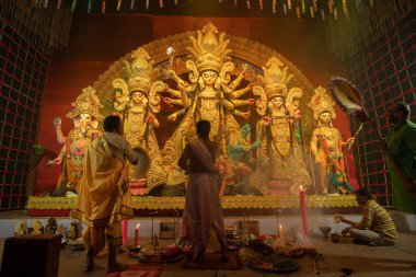 Howrah, Batı Bengal, Hindistan - 3 Ekim 2022: Hindu rahipler kabuk kabuğuyla tanrıça Durga 'ya tapıyorlar. Ashtami puja aarati - kutsal Durga Puja ritüeli - Hinduizm festivali geceleri gerçekleştiriliyor.