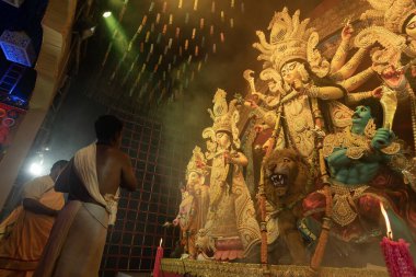 Howrah, Batı Bengal, Hindistan - 3 Ekim 2022: Hindu Rahibi Tanrıça Durga 'ya tapıyor. Ashtami puja aarati - Durga Puja ritüeli - Hinduizm festivali gece pandalında gerçekleştiriliyor.