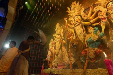 Howrah, Batı Bengal, Hindistan - 3 Ekim 2022: Hindu Rahip 'in tanrıça Durga' ya tapması, sinek çırpma fanı. Gece Ashtami puja aarati. Durga puja soyut, soyut bir kültür mirası..