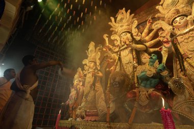 Howrah, Batı Bengal, Hindistan - 3 Ekim 2022: Hindu Rahip 'in tanrıça Durga' ya tapması, sinek çırpma fanı. Gece Ashtami puja aarati. Durga puja soyut, soyut bir kültür mirası..
