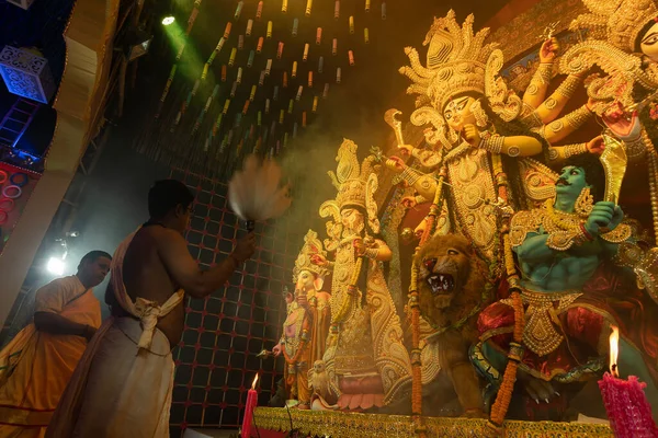 Howrah, Batı Bengal, Hindistan - 3 Ekim 2022: Hindu Rahip 'in tanrıça Durga' ya tapması, sinek çırpma fanı. Gece Ashtami puja aarati. Durga puja soyut, soyut bir kültür mirası..