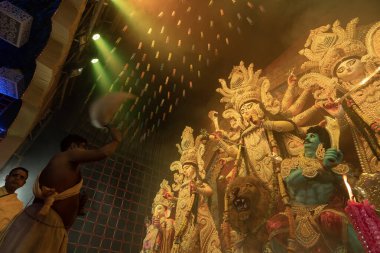 Howrah, Batı Bengal, Hindistan - 3 Ekim 2022: Hindu Rahip 'in tanrıça Durga' ya tapması, sinek çırpma fanı. Gece Ashtami puja aarati. Durga puja soyut, soyut bir kültür mirası..