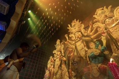 Howrah, Batı Bengal, Hindistan - 3 Ekim 2022: Hindu Rahip 'in tanrıça Durga' ya tapması, sinek çırpma fanı. Gece Ashtami puja aarati. Durga puja soyut, soyut bir kültür mirası..