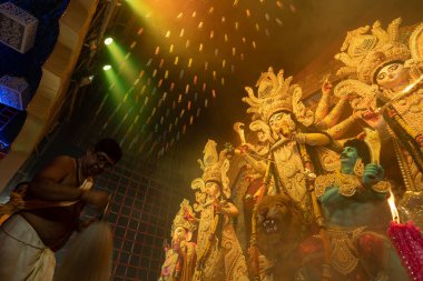 Howrah, Batı Bengal, Hindistan - 3 Ekim 2022: Hindu Rahip 'in tanrıça Durga' ya tapması, sinek çırpma fanı. Gece Ashtami puja aarati. Durga puja soyut, soyut bir kültür mirası..