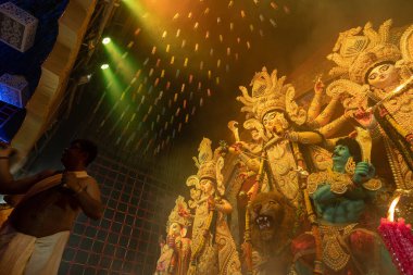 Howrah, Batı Bengal, Hindistan - 3 Ekim 2022: Hindu Rahibi Tanrıça Durga 'ya tapıyor. Ashtami puja aarati - Durga Puja ritüeli - Hinduizm festivali gece pandalında gerçekleştiriliyor.