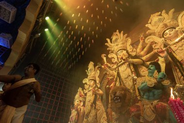 Howrah, Batı Bengal, Hindistan - 3 Ekim 2022: Hindu Rahibi Tanrıça Durga 'ya tapıyor. Ashtami puja aarati - Durga Puja ritüeli - Hinduizm festivali gece pandalında gerçekleştiriliyor.