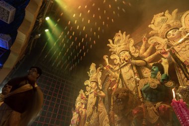 Howrah, Batı Bengal, Hindistan - 3 Ekim 2022: Hindu Rahip 'in tanrıça Durga' ya tapması, sinek çırpma fanı. Gece Ashtami puja aarati. Durga puja soyut, soyut bir kültür mirası..