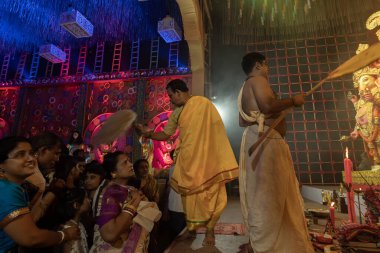 Howrah, Batı Bengal, Hindistan - 3 Ekim 2022: Hindu Rahiplerin kutsaması Chamor ile dua edenler, Durga Puja pandalının içinde fanı çırpın. Gece Ashtami puja aarati. Hinduizm 'in en büyük fetsivası.