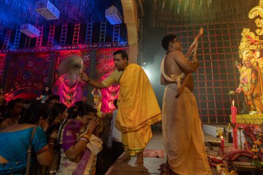 Howrah, Batı Bengal, Hindistan - 3 Ekim 2022: Hindu Rahiplerin kutsaması Chamor ile dua edenler, Durga Puja pandalının içinde fanı çırpın. Gece Ashtami puja aarati. Hinduizm 'in en büyük fetsivası.