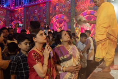 Howrah, Batı Bengal, Hindistan - 3 Ekim 2022: Hindu Bengali sarili kadın, Durga Puja Pandali 'nin içinde elleri bağlı tanrıça Durga' ya dua ediyor. Hinduizm 'in en büyük fetsivası.