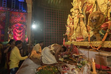 Howrah, Batı Bengal, Hindistan- 3 Ekim 2022: Hindu Rahip saygı göstererek, dua ederek ve tanrıça Durga 'ya taparak diz çöker. Puja Pandalı. Durga puja soyut, soyut bir kültür mirası..