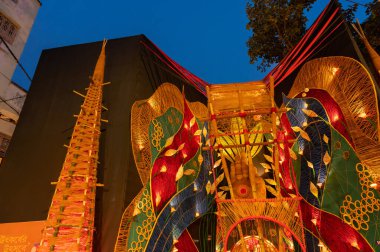 Howrah, Batı Bengal, Hindistan - 3 Ekim 2022: Madalyalı Durga Puja pandalının dış görünüşü. Durga Puja, tüm dünyada kutlanan en büyük Hinduizm festivali. Mavi gökyüzü arka planı. Mavi saat..