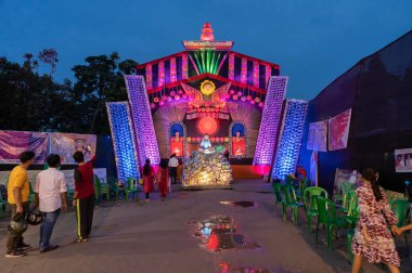 Howrah, Batı Bengal, Hindistan - 3 Ekim 2022: Durga Puja pandalını ziyaret edenler. Durga Puja, tüm dünyada kutlanan en büyük Hinduizm festivali. Mavi gökyüzü arka planı. Mavi saat..