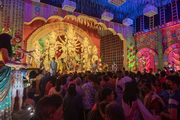 stock image Howrah,West Bengal,India- 4th October, 2022 : Hindu devotees praying and worshipping Goddess Durga, inside decorated Durga Puja Pandal at night. Durga puja is unesco intangible cultural heritage.