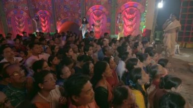 Howrah, West Bengal, India- 3 Ekim 2022: Hindu safohit Sanskrit shlokas, içinde Durga Puja Pandalı süslenmiş Durga 'ya ibadet ve dua için ittirme fanatikleri rehberlik.