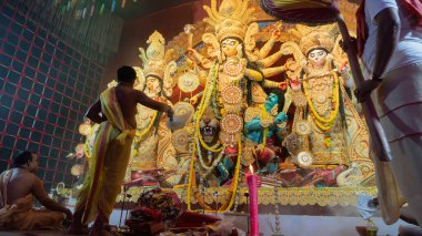 Howrah, Batı Bengal, Hindistan - 5 Ekim 2022: Hindu Rahip 'in tanrıça Durga' ya tapması, sinek çırpma fanı. Gece Ashtami puja aarati. Durga puja soyut, soyut bir kültür mirası..