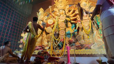 Howrah, Batı Bengal, Hindistan - 5 Ekim 2022: Hindu Rahip 'in tanrıça Durga' ya tapması, sinek çırpma fanı. Gece Ashtami puja aarati. Durga puja soyut, soyut bir kültür mirası..